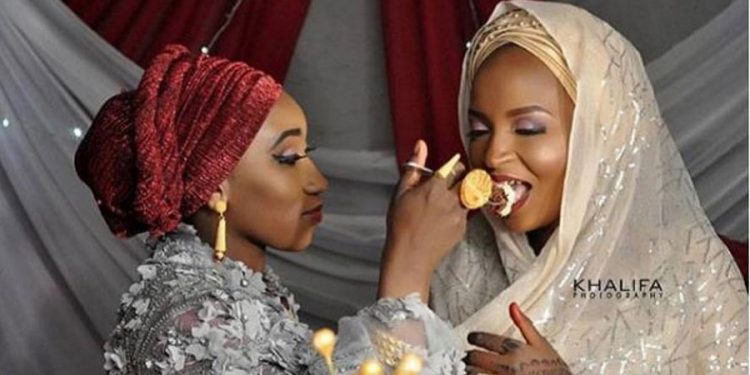 First wife feeds her husband’s second wife on their wedding day
